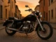 Honda Shadow 125 VT noire sur rue pavée au coucher du soleil, moto custom élégante aux chromes brillants, vue trois-quarts en France